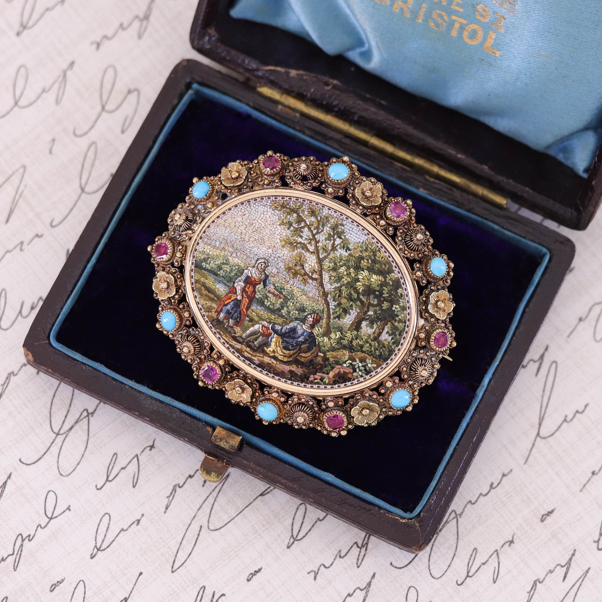 An exceptional micromosaic brooch (circa 1800) reminiscent of a fine renaissance era painting depicting a pasture seen of a man and woman under a tree.