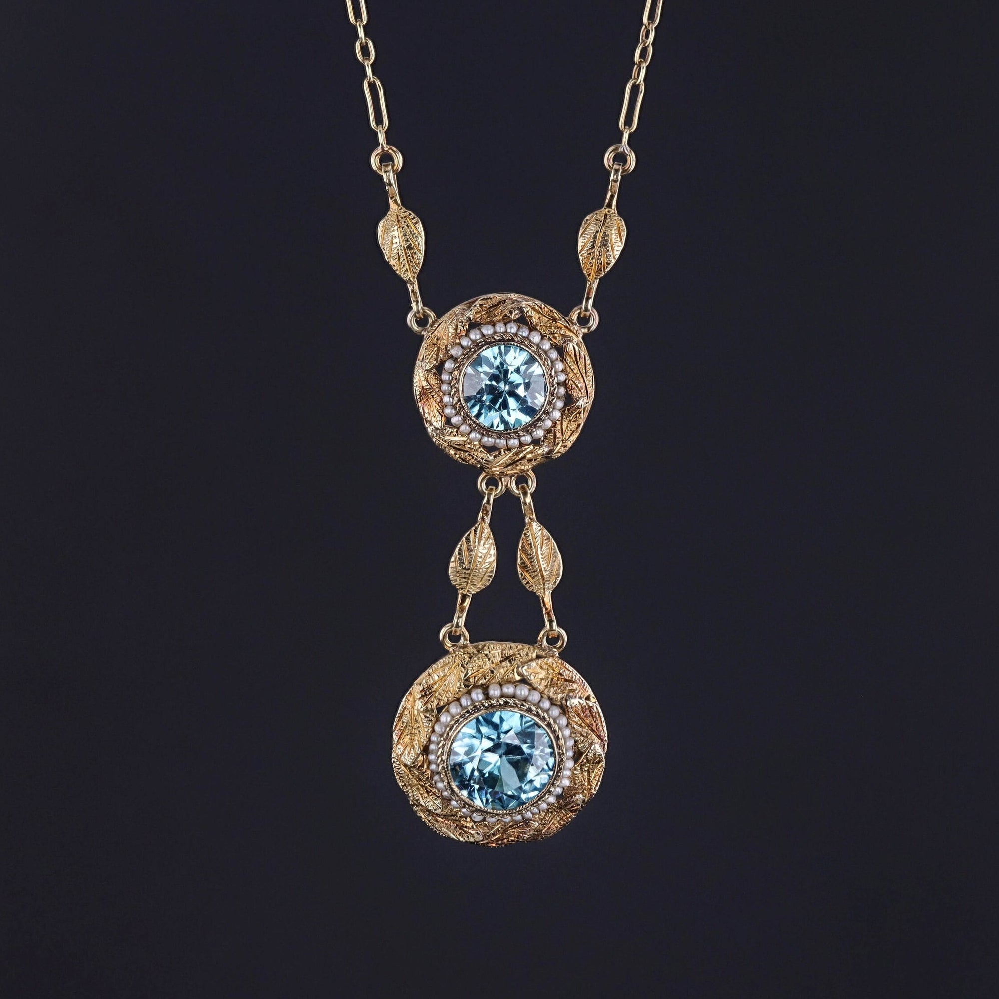 A dazzling Victorian necklace with sparkling blue zircon in frames of tiny pearls and 14k leaves.
