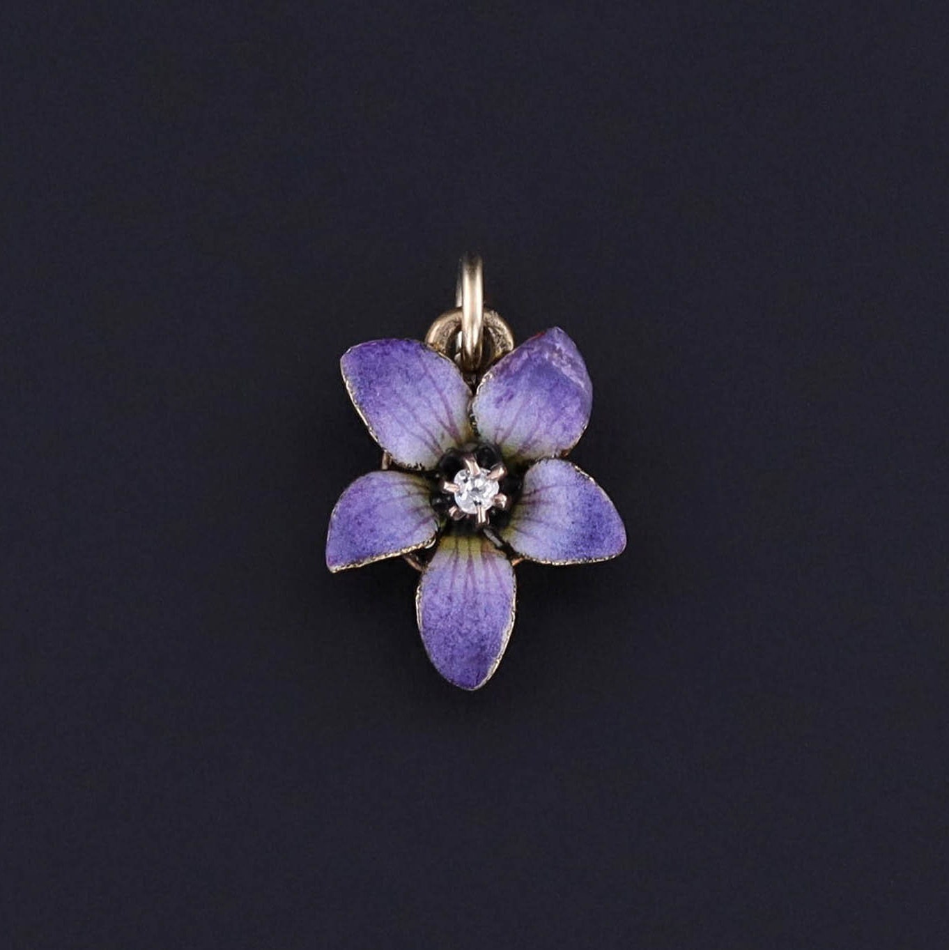 An antique enamel violet charm with a diamond accent. The charm is 14k gold and was originally an antique stickpin. Perfect for any flower lover or collector of antique jewelry. Also perfect for anyone with a charm bracelet or charm necklace.
