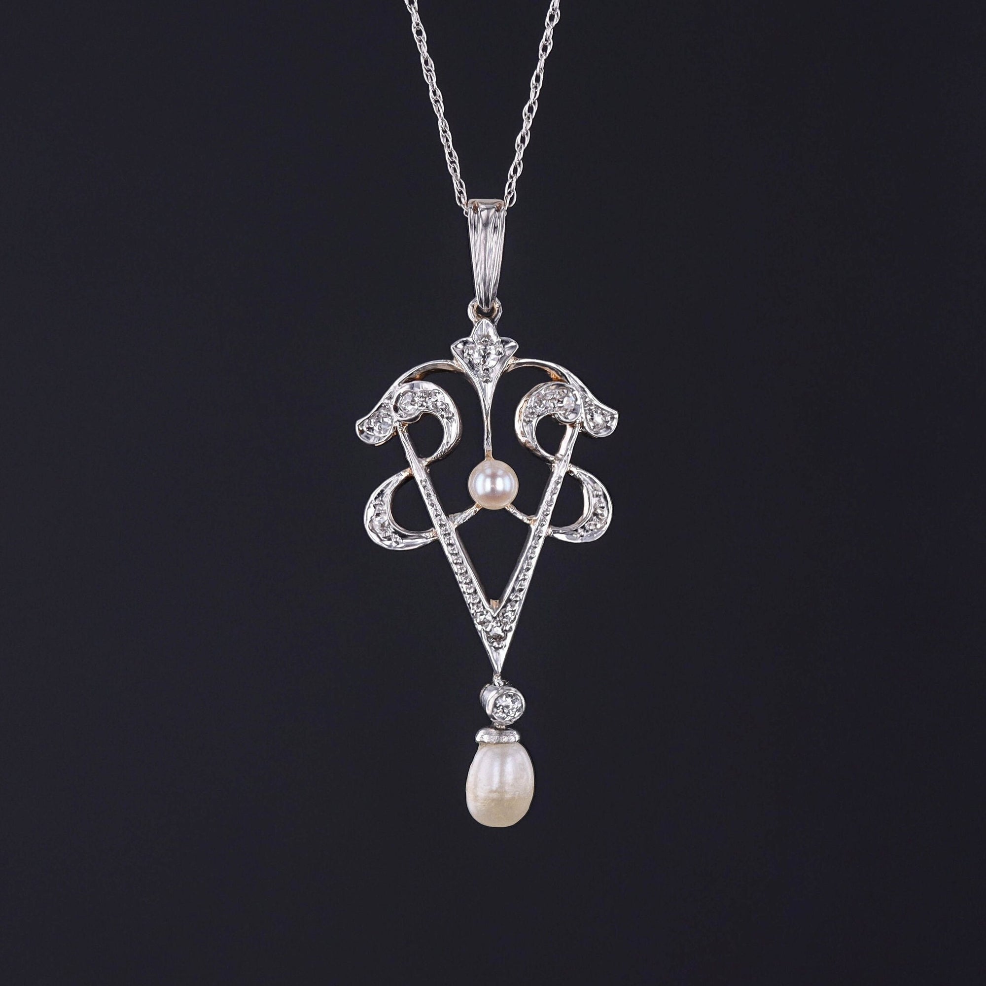 Step into the elegance of the early 20th century with this antique lavalier necklace. The pendant is platinum topped 14k gold and accented with diamonds and pearls. It is accompanied by an 18 inch, 10k white gold chain.