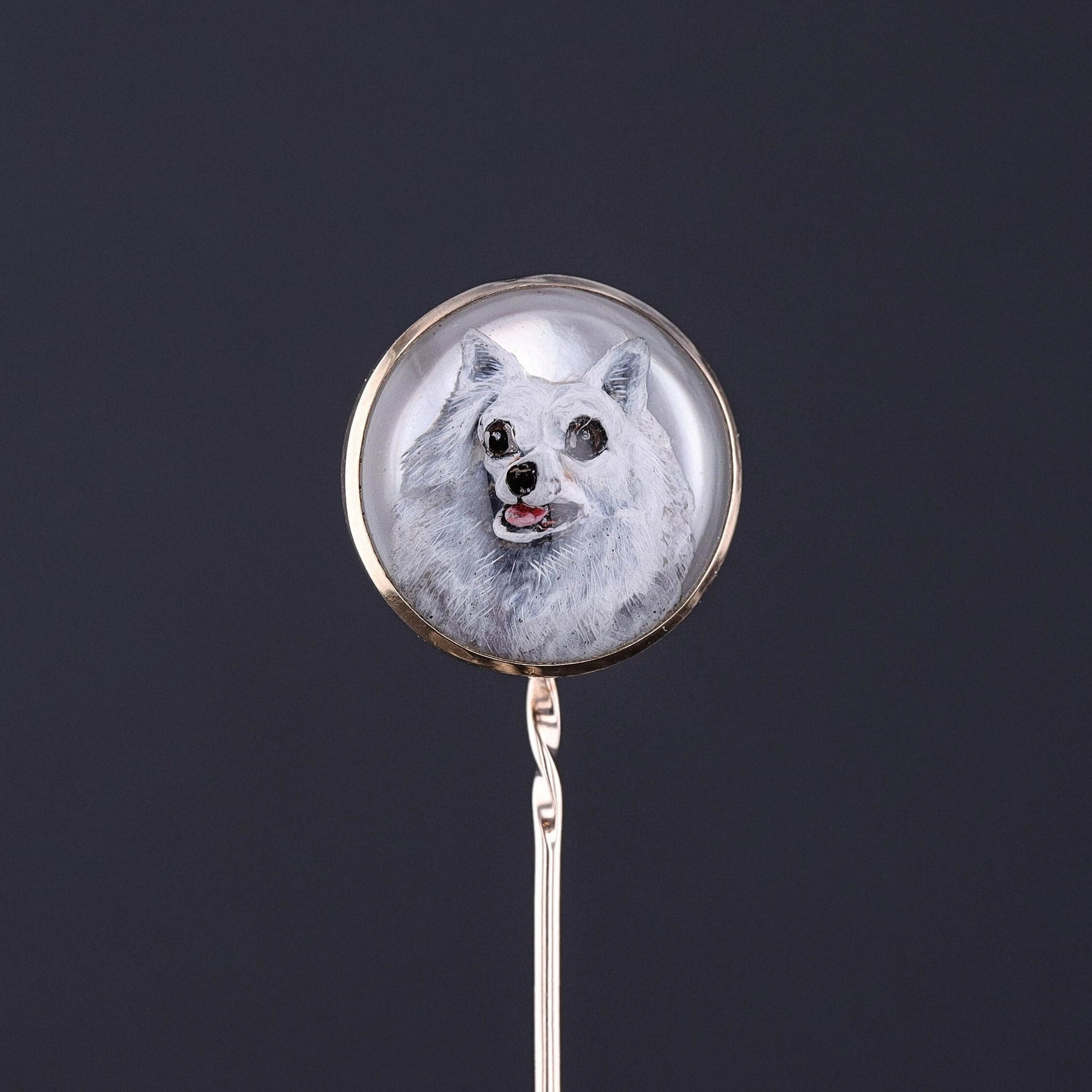 A beautifully detailed reverse painting of a Pomeranian or an American Eskimo. The polished domed crystal is set in 9ct gold.