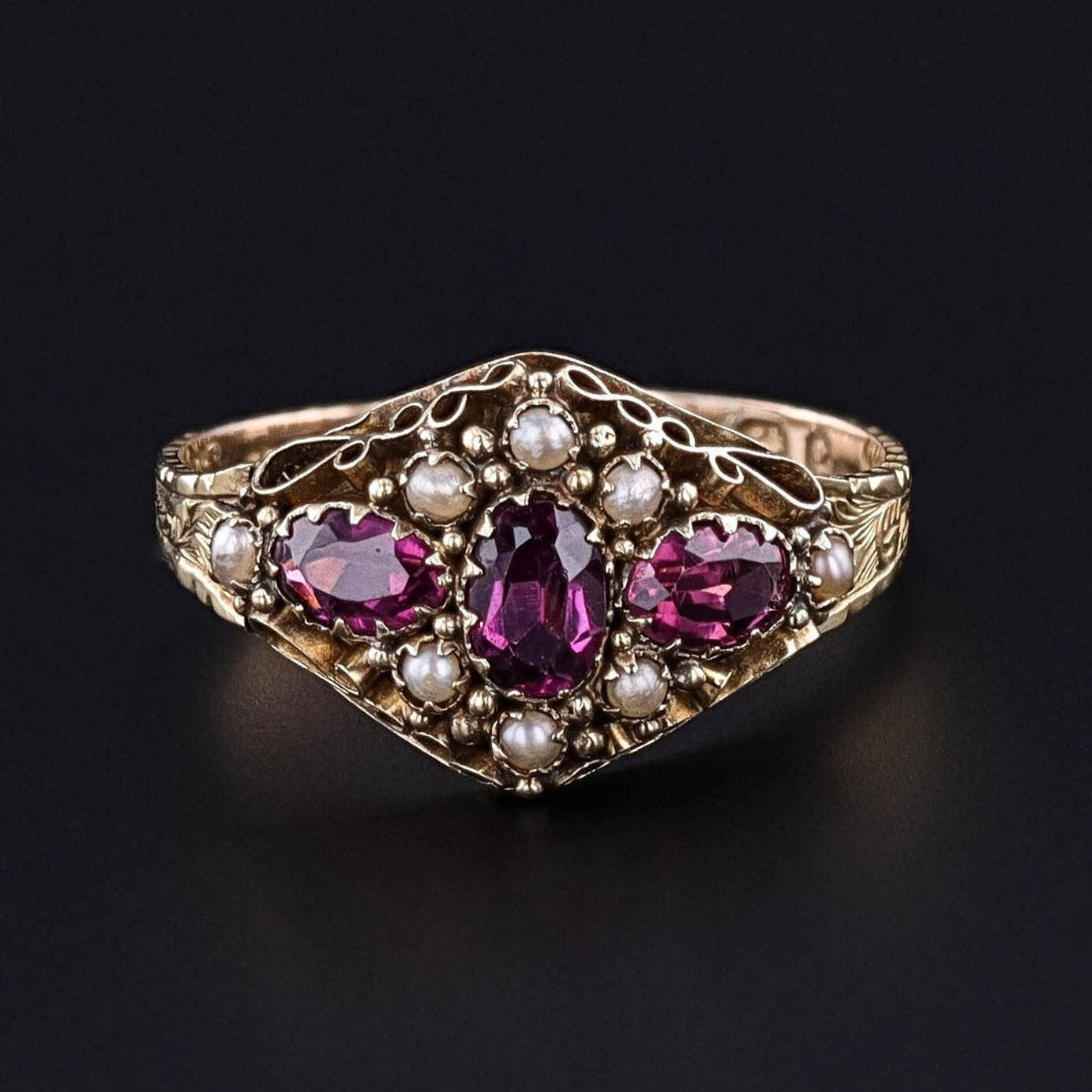 The front of our antique rhodolite garnet and pearl ring with an hand engraved band. The ring dates to the late Georgian era.