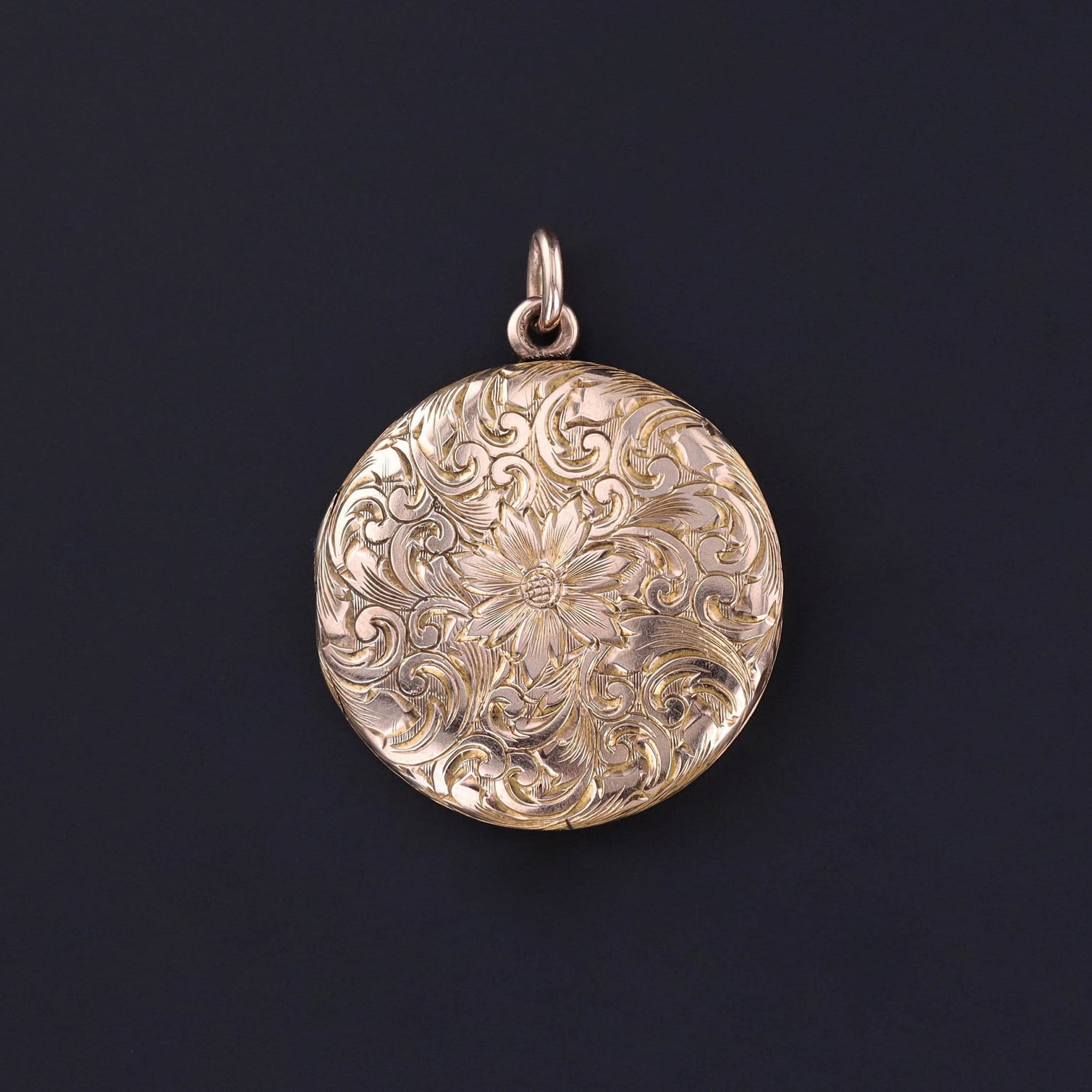 Antique Hand Etched Floral Locket: Peer into the past with this antique 9ct gold locket (circa 1910) adorned with a hand etched floral design. The interior opens to expose a photo of a young man and the reverse bears the initials &#39;GMM&#39;.