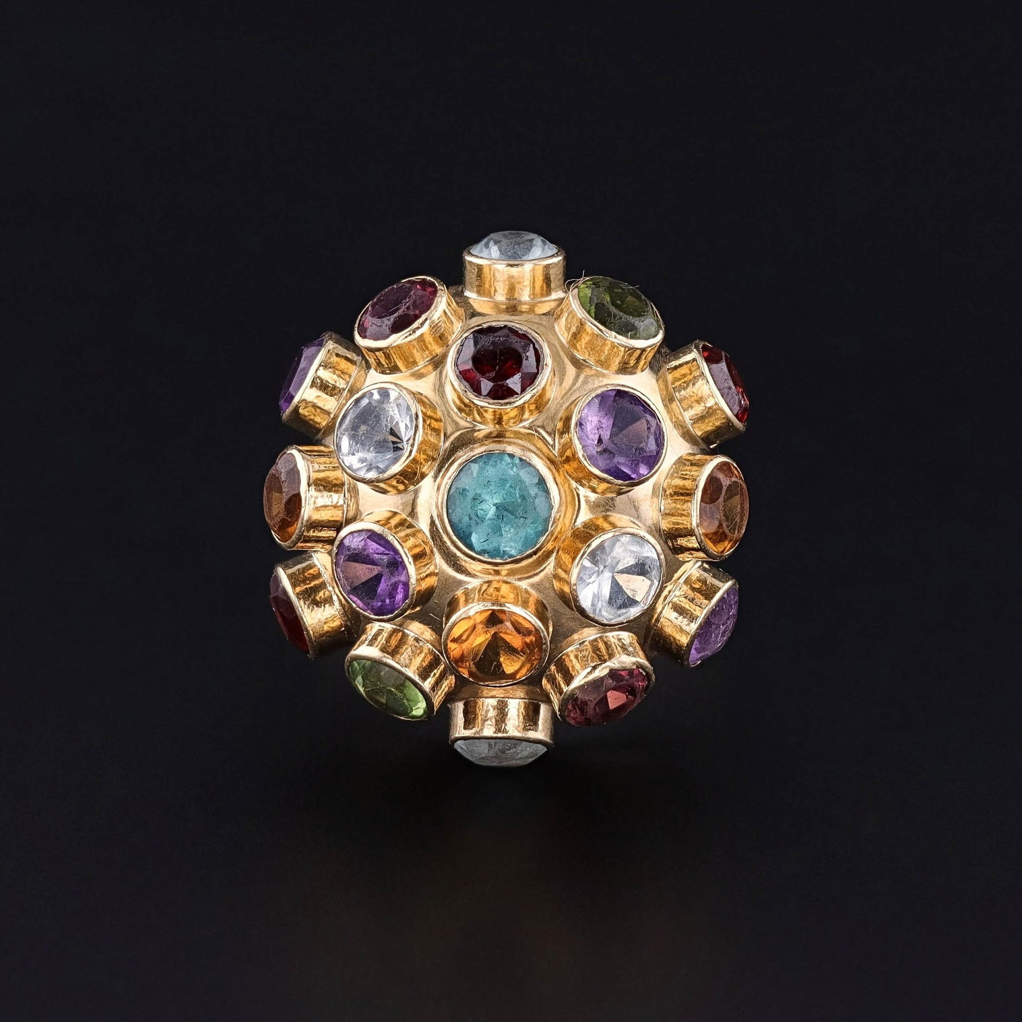 A 1960s Sputnik style gemstone ring showcasing a colorful array of assorted gemstones mounted in 18k gold. The ring features tourmaline, amethyst, citrine, peridot, garnet, and spodumene. Perfect for any mid-century jewelry collector.