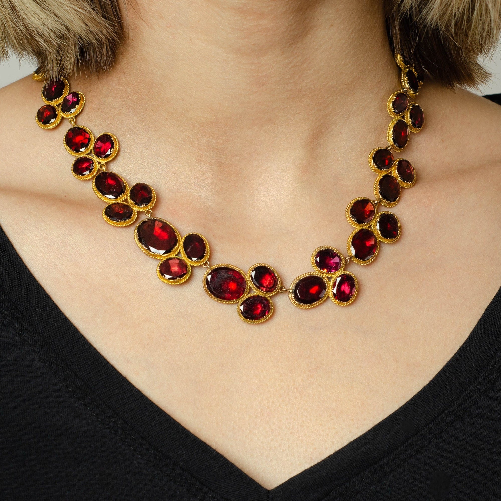 An exceptional antique necklace dating back to the late Georgian era (circa 1820). This exquisite antique jewel showcases 54 oval flat-cut, foil backed garnets, set in 14k gold. It is a timeless piece perfect for any occasion.