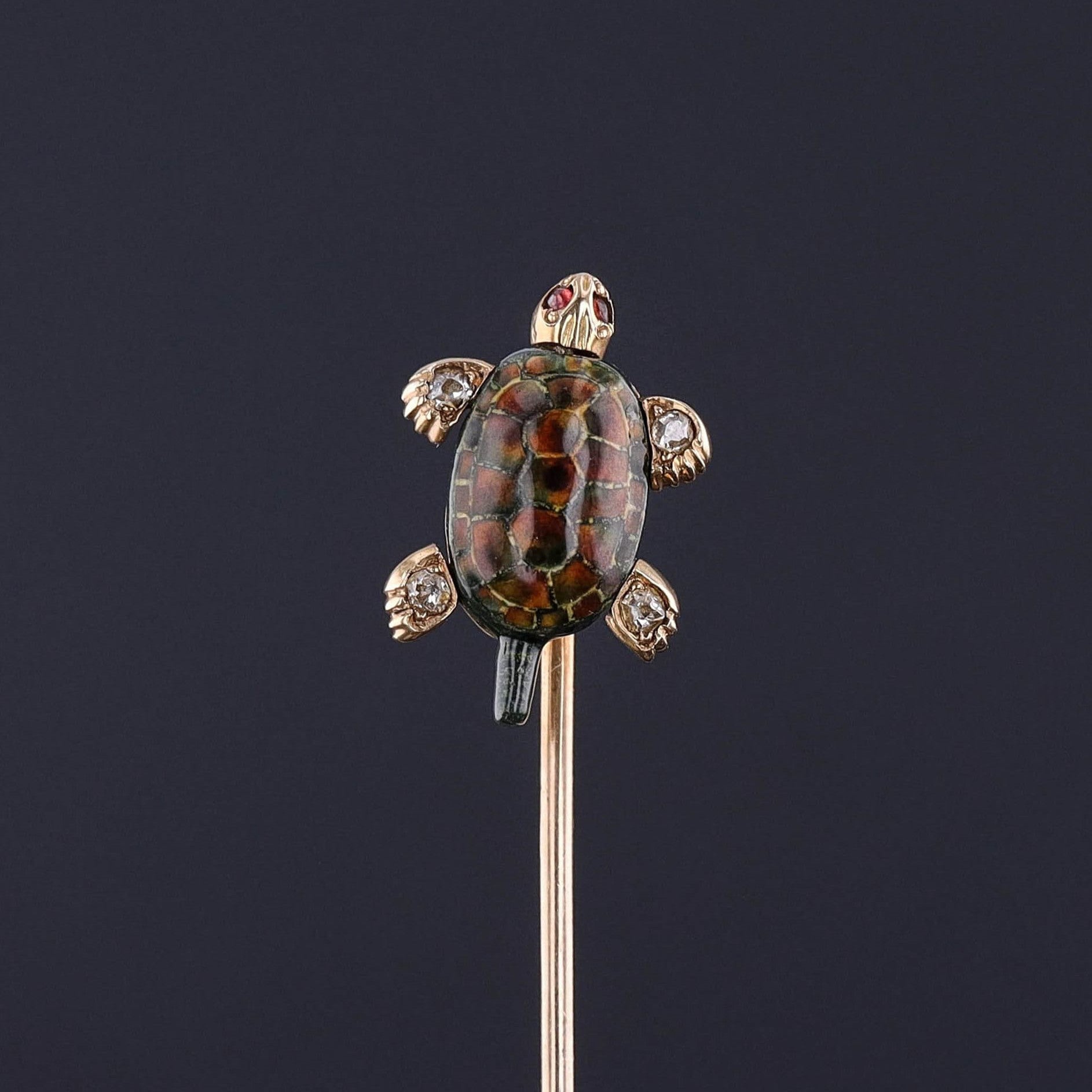 An exceptional antique stickpin with moveable feet and a moveable head. The feet are accented with diamonds and the eyes are garnets. The shell is finely done enamel and the entire pin is 14k gold.