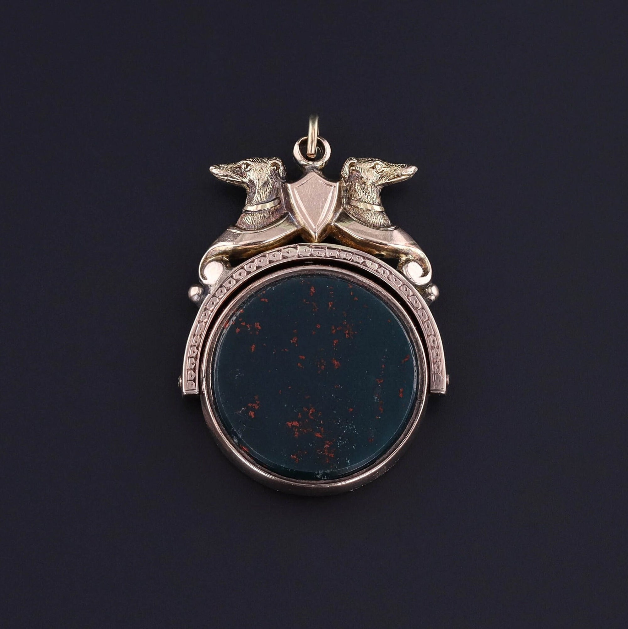 A Victorian era Greyhound dog pendant that flips to show a bloodstone on one side and a carnelian on the other. Perfect for anyone with a love of greyhounds or any antique jewelry collector.
