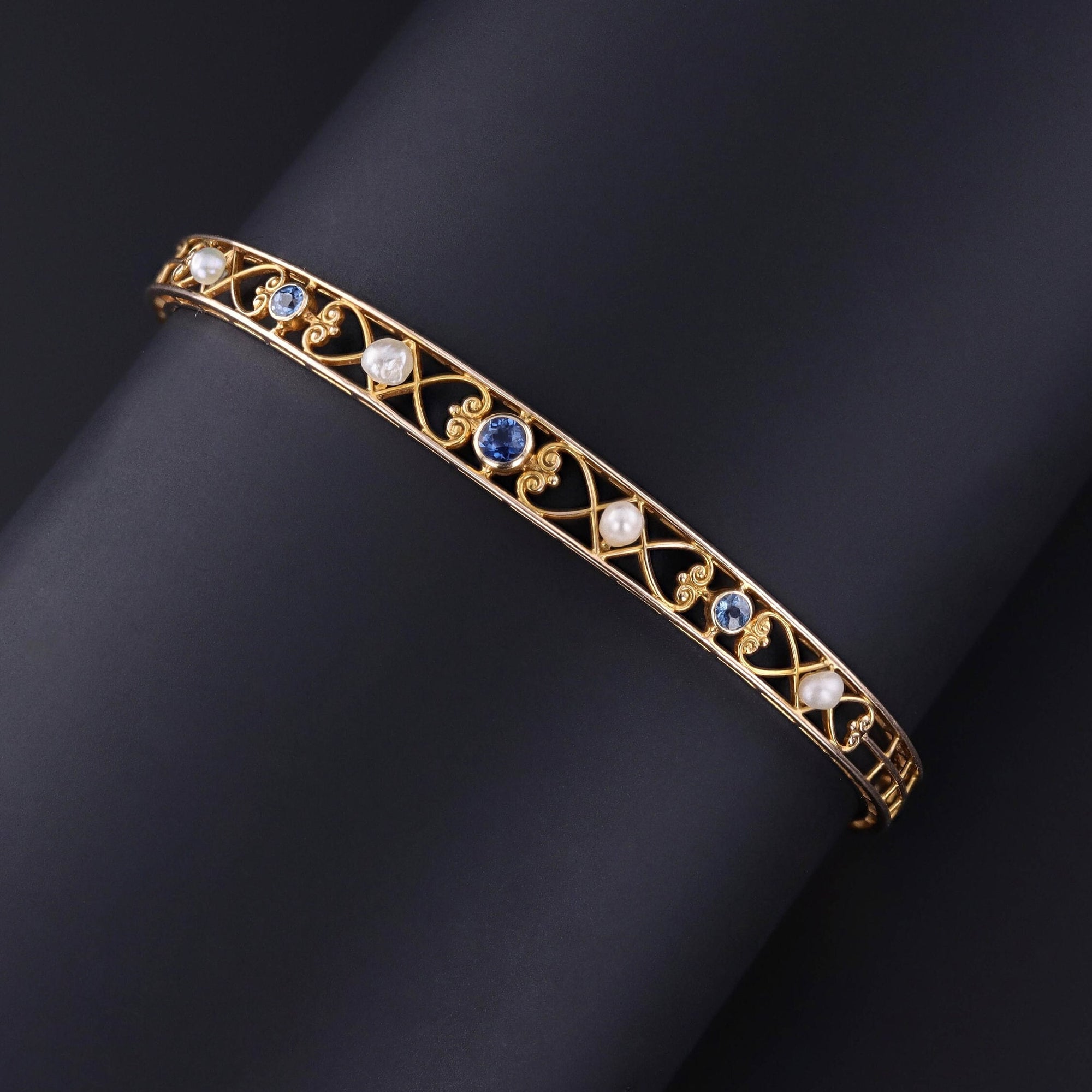 Step into the elegance of the 1920s with this antique bracelet featuring sapphires and pearls intricately set in 14k gold filigree. The inside bears the maker&#39;s mark for the renowned Alling & Co. of Newark, NJ.
