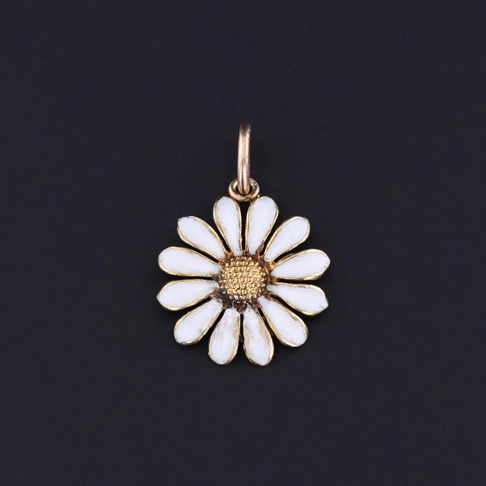 An antique white enamel daisy charm of 14k gold. The piece was originally a pin from the early 1900s. Perfect for any charm bracelet or charm necklace. It would also look great won by itself on a simple chain. A great gift for a flower lover.