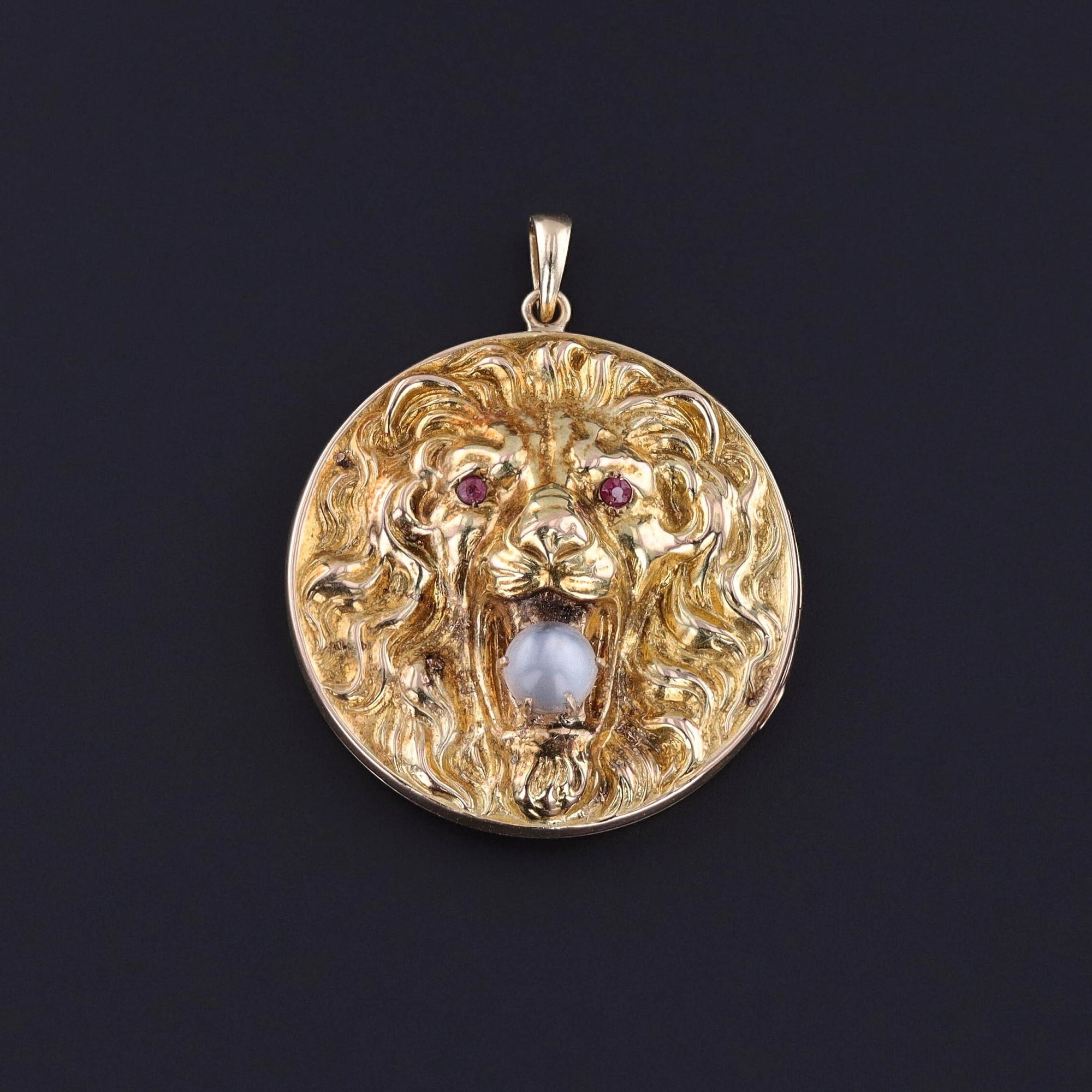 An antique lion locket from the Art Nouveau era. The piece is 10k gold and the lion has a moonstone bead in its teeth. The piece is in good condition and perfect for everyday wear.