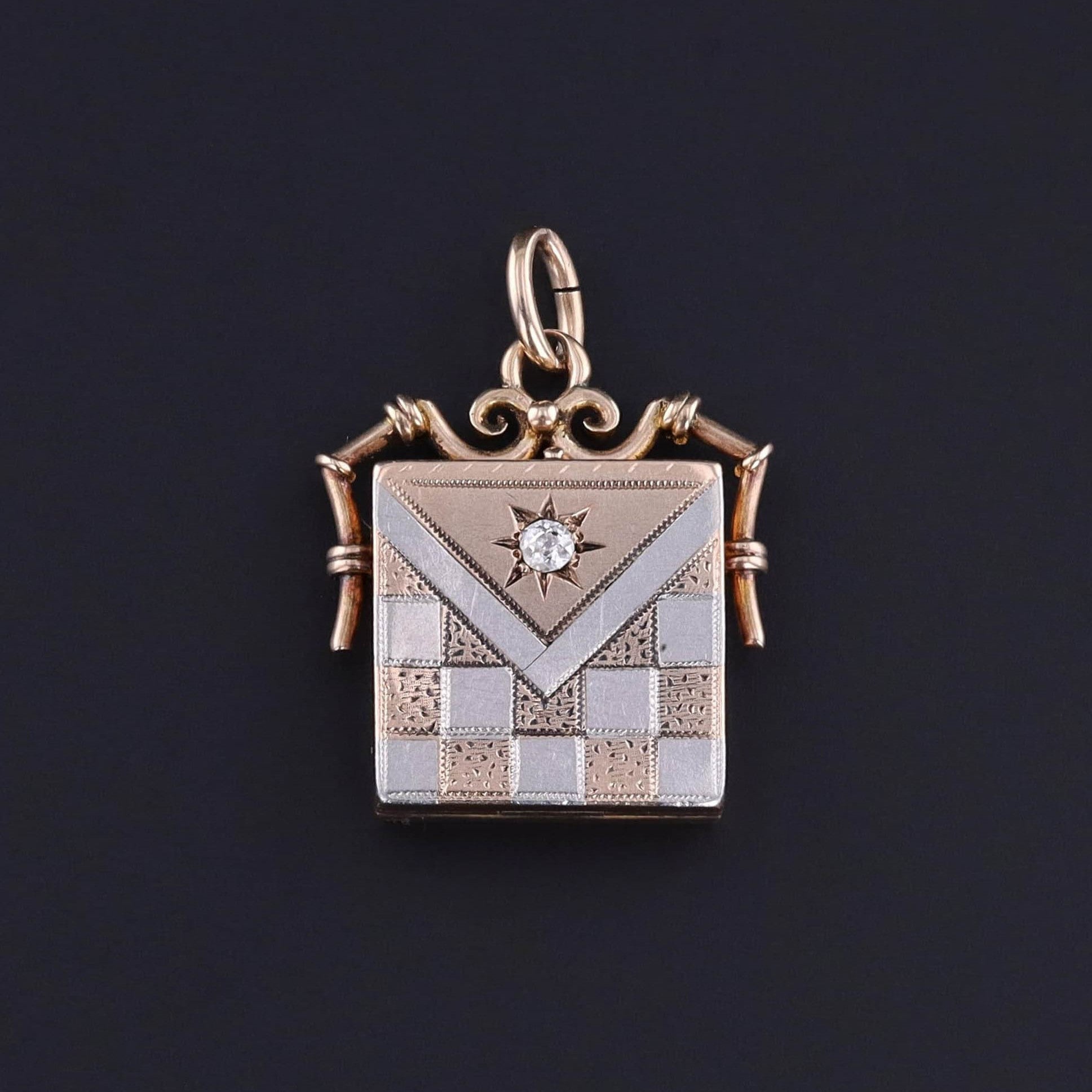 A fine antique locket from the early 20th century circa 1900-1910. It is 10k rose gold and platinum with an old European cut diamond accent. It has an appearling hand etched checkerboard pattern. Perfect for any antique jewelry lover.