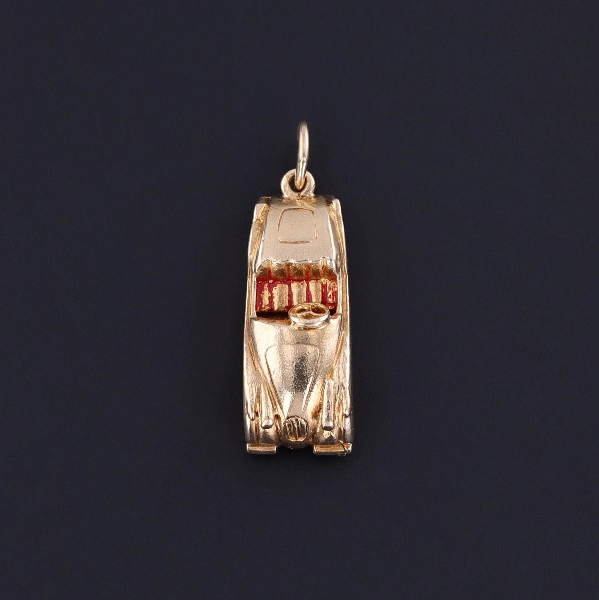 A vintage 14k gold convertible car charm dating to the 1950s. The charm is solid gold and in good condition with some wear to the enamel.