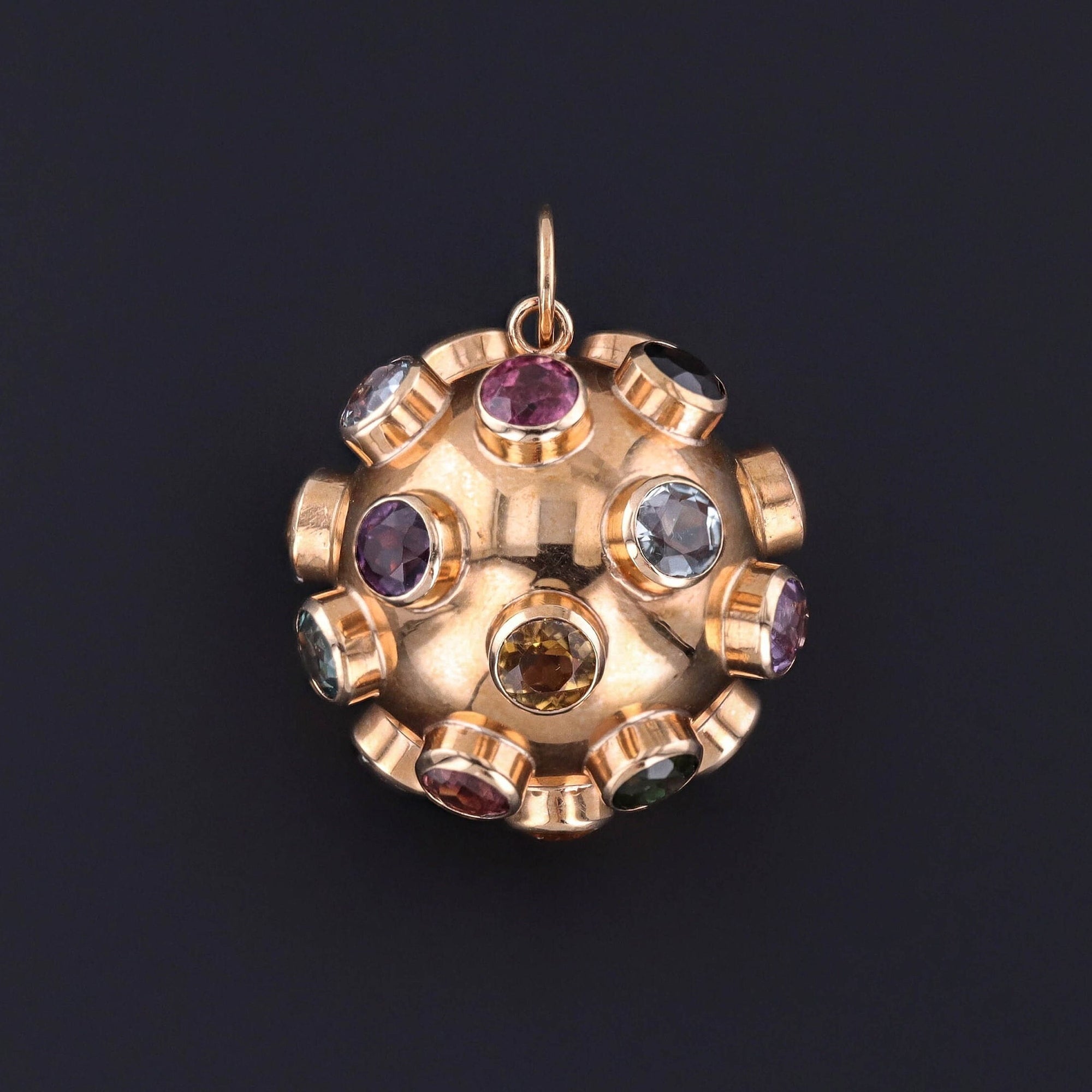 A 1960s vintage gemstone sputnik satellite inspired pendant of 18k gold. The piece is adorned with an array of colorful gemstones. A perfect mid-century jewel, the orb is quite collectible.