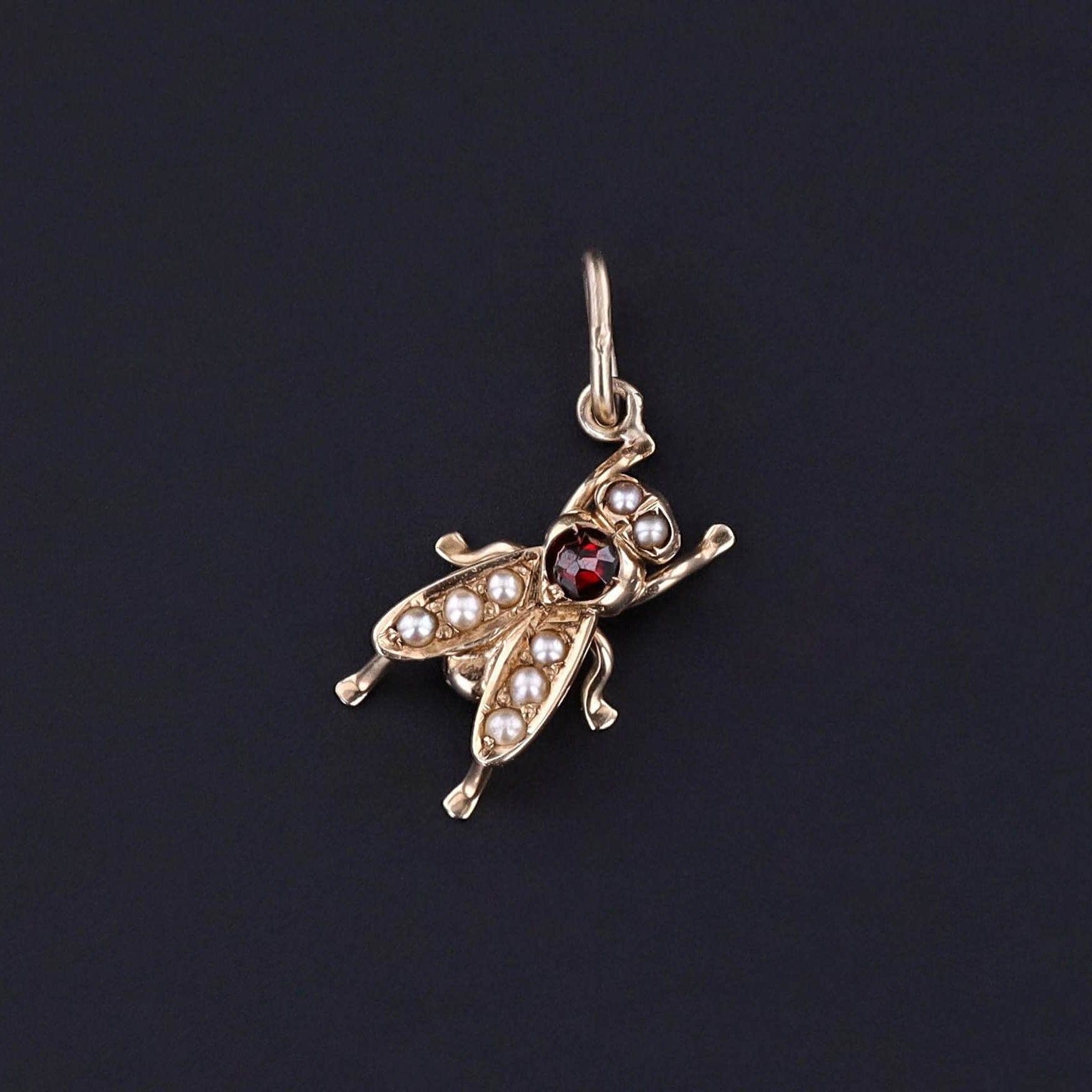 An antique fly charm created from a stickpin. The piece is 14k gold with pearls and a garnet and in great condition. Perfect for any charm bracelet, charm necklace, or chain.