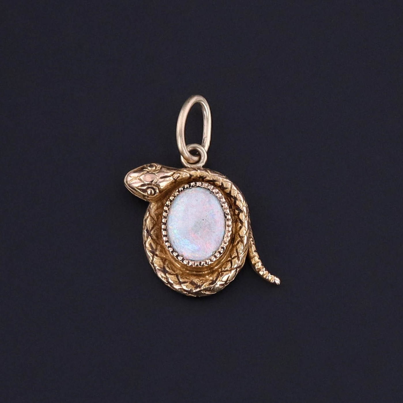 An antique 14k gold and opal snake charm created from a stick pin circa 1900. The antique charm is in great condition and perfect for any antique jewelry lover or charm collector. It would look great on a bracelet or chain.
