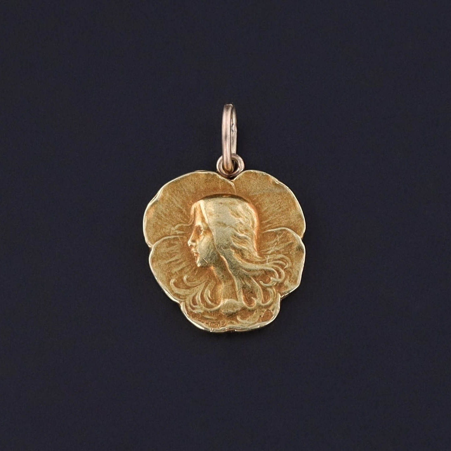 An antique French pansy woman charm from the Art Nouveau era. The 18k gold pendant was originally an antique stickpin. Perfect for any antique jewelry collector or lover of Art Nouveau.