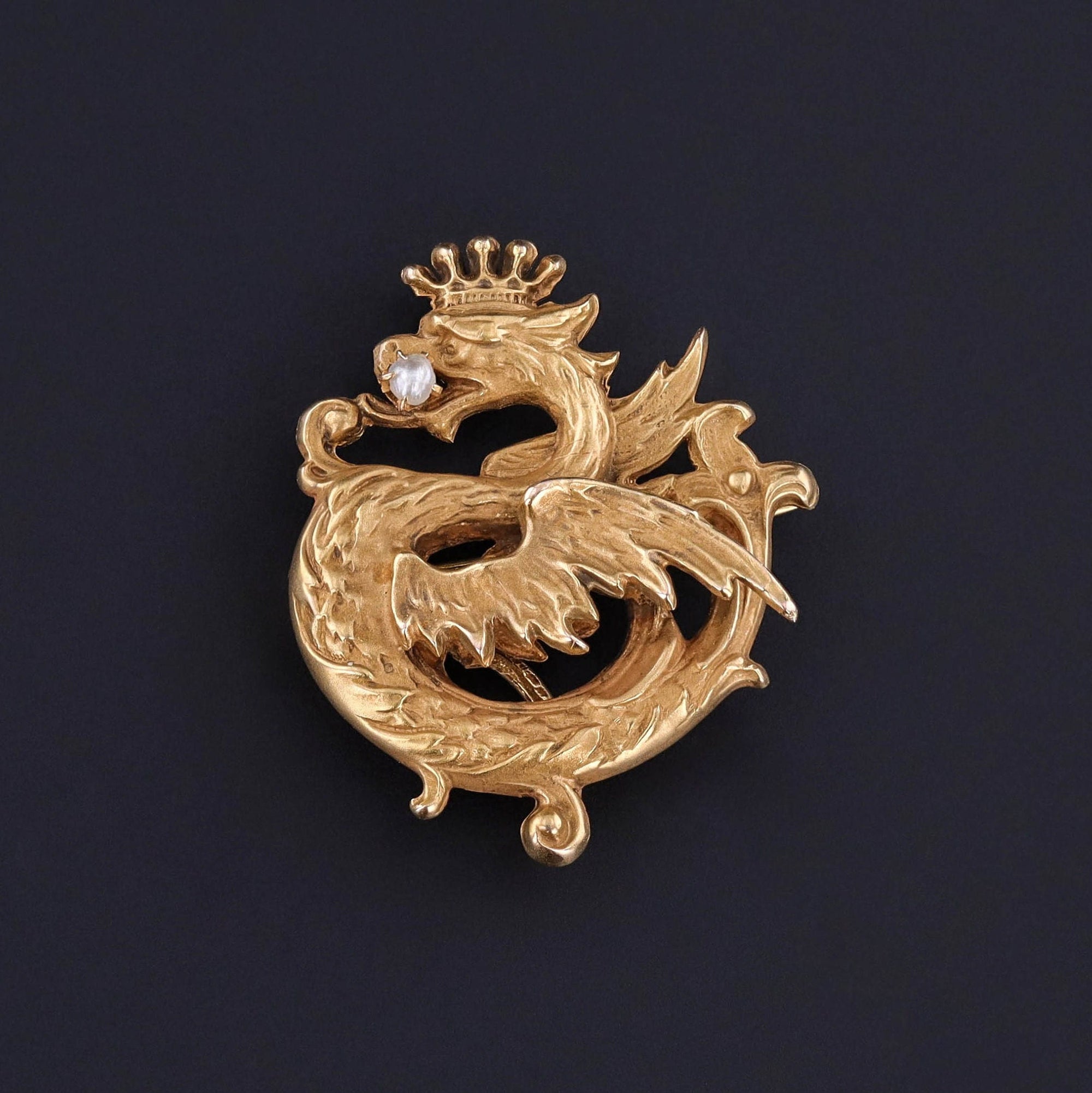 An antique griffin watch pin from the Edwardian era. The pin is crafted of 10k gold and the griffin is adorned with a pearl. It is in great condition and perfect for any gentleman&#39;s lapel. A perfect unisex piece.