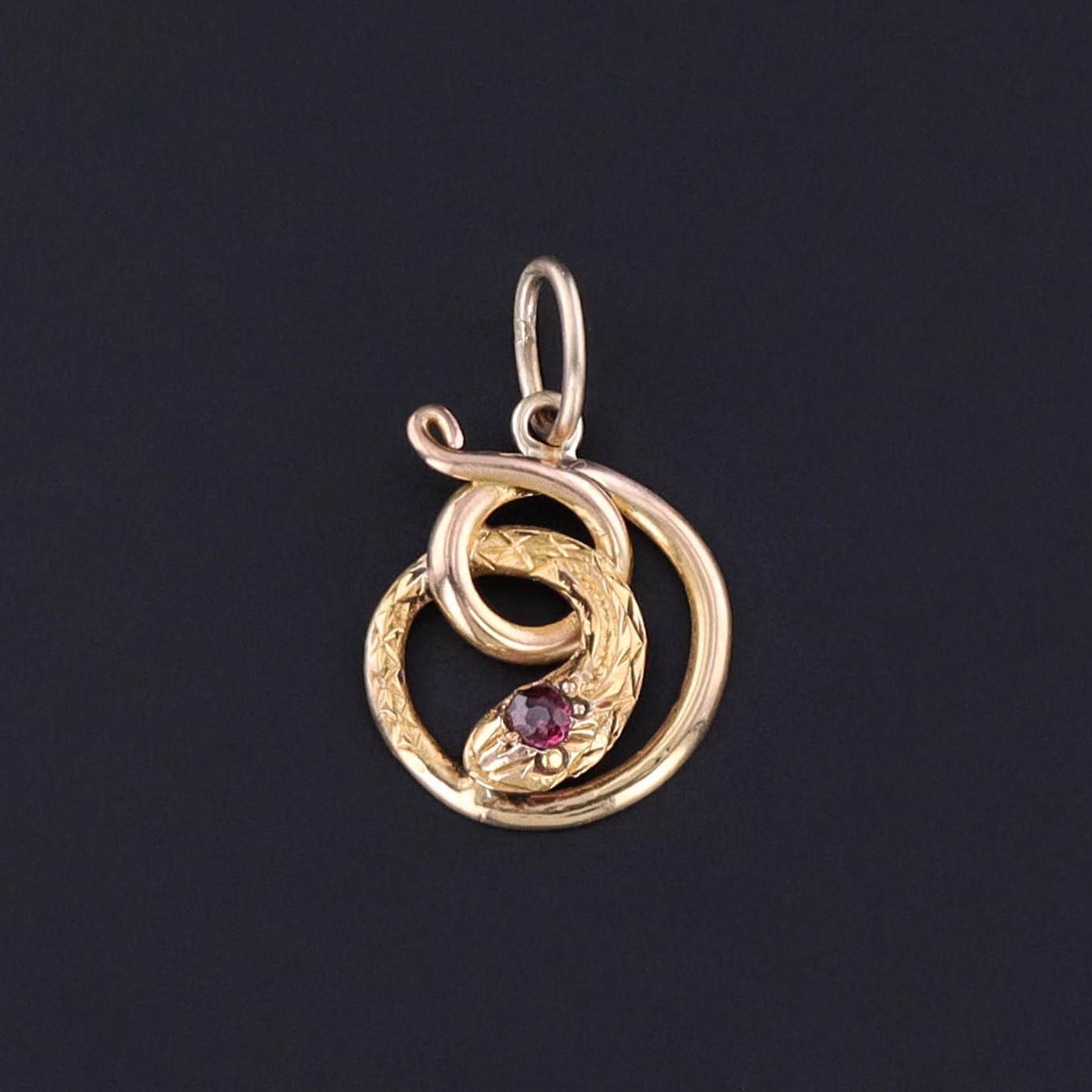 An antique 18k gold and garnet snake charm created from an antique stickpin. The repurposed or upcycled piece is perfect for any vintage lover or fan of repurposed jewelry.