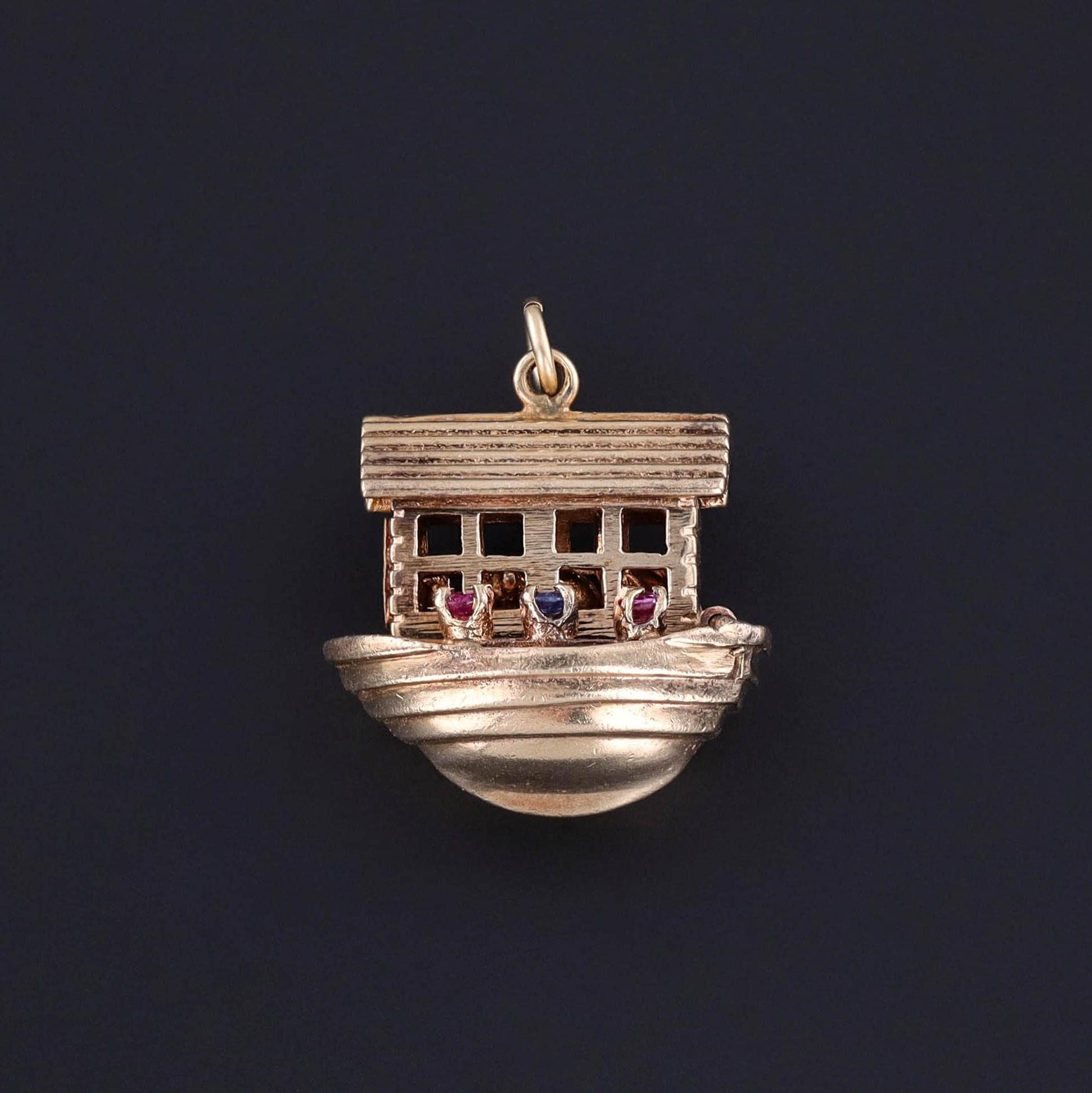 A vintage Noah&#39;s Ark charm that opens to expose golden animals. The 14k gold charm is adorned with rubies and sapphires and dates to the 1940s-1960s. Perfect for anyone of Christian faith or any charm collector.