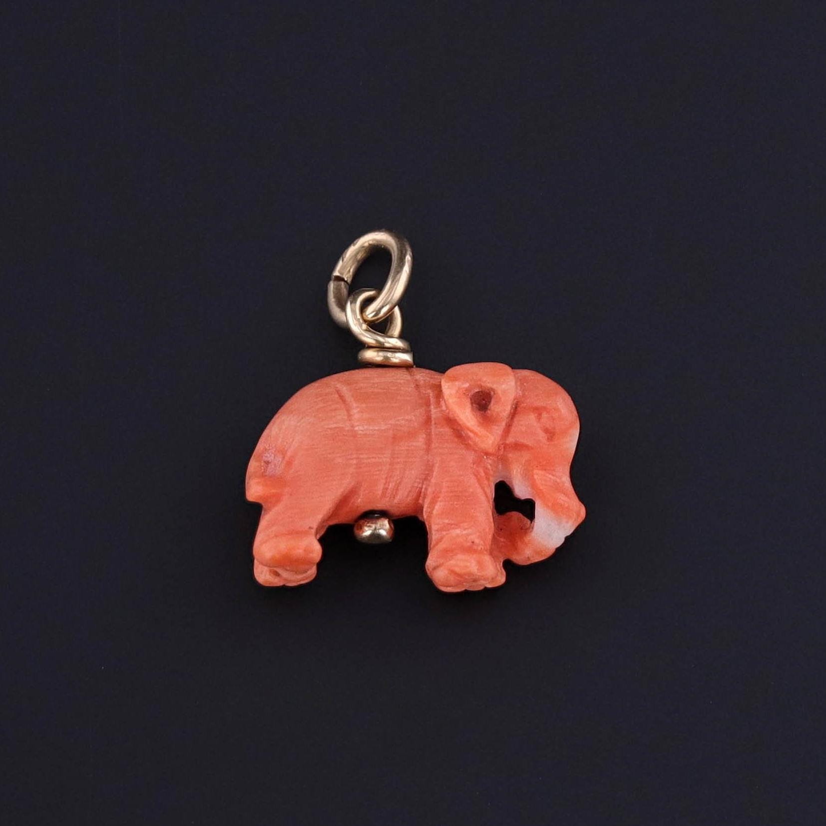 A vintage coral elephant with a 14k gold bail.
