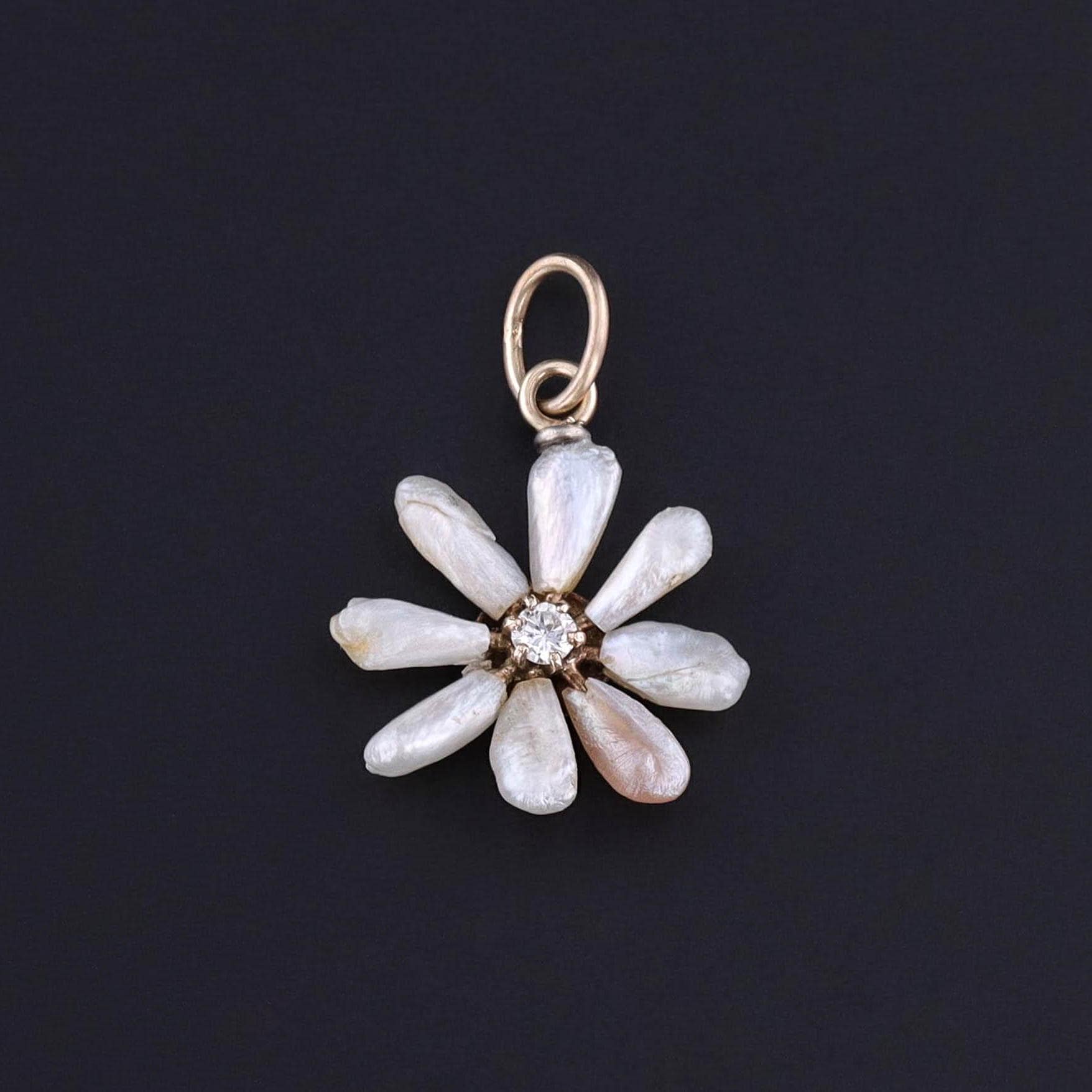 An antique pearl daisy charm of 14k gold. It was originally an antique stickpin with a diamond at its center. Perfect for any daisy lover, anyone named Daisy, or anyone with a love of flowers or antique jewelry.